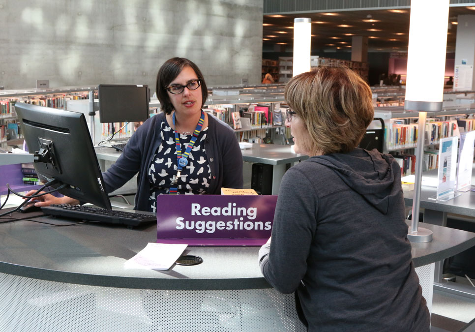 Reader’s services librarian with patron in the living room at the Central Library