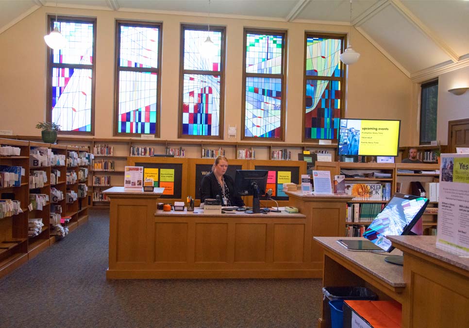 Library staff at the service desk area at the Queen Anne Branch