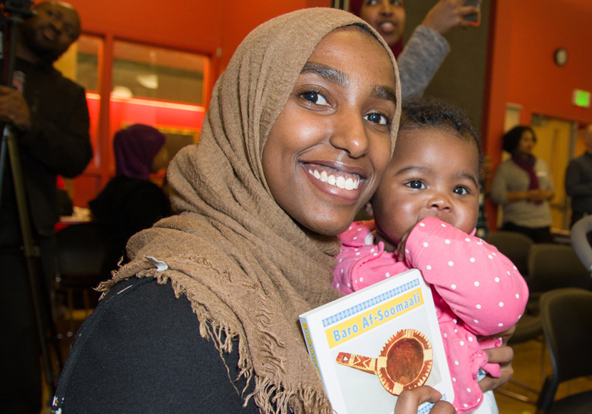 Somali patron with child holding Baro Af-Soomaali