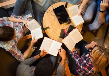 people gathered at a table with books