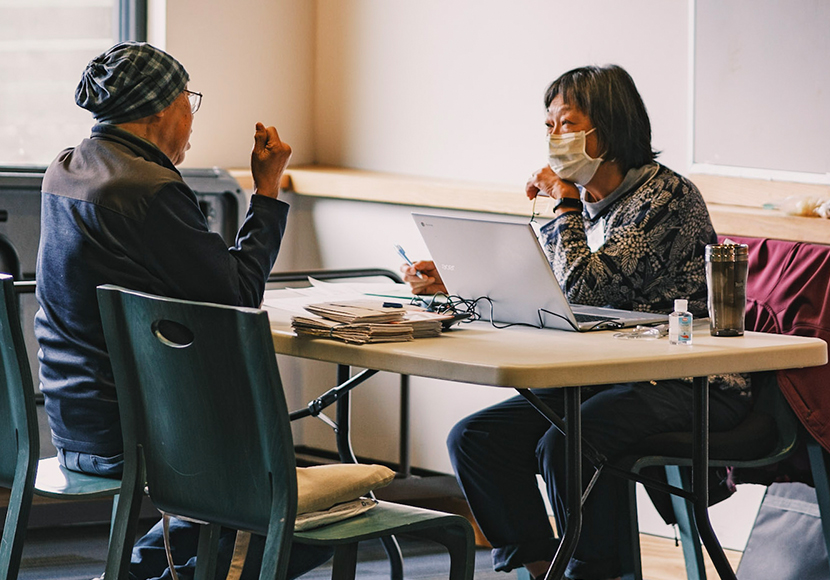 Two people sitting at a table, facing each other.