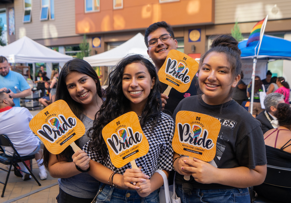 Library staff, friends and family holding SPL fans at Seattle Latinx Pride in 2019